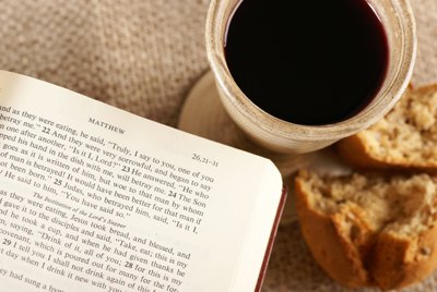 Jus de raisin, pain au levain, et Bible ouverte à l’Évangile de Matthieu, au chapitre 26, versets 21 à 31, symboles de la Nouvelle Alliance en Son sang et en Son corps, notre substitut, commémorée lors de la Sainte Cène.