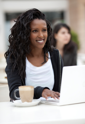 jeune femme souriante qui travaille sur un ordinateur portable