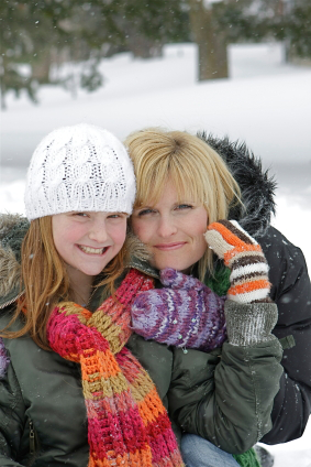 mother and daughter embracing in the snow