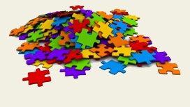 Pièces de puzzle de différentes couleurs (rouge, bleu, violet, orange, vert, jaune) non assemblées, en un grand tas désordonné.