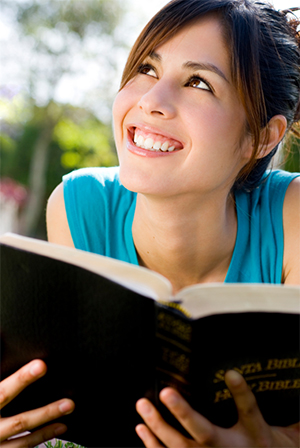 jovencita sonriente leyendo la Biblia