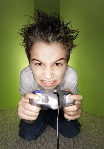 Jeune garçon nerveux, enragé et en colère, jouant à des jeux vidéo, tenant une manette