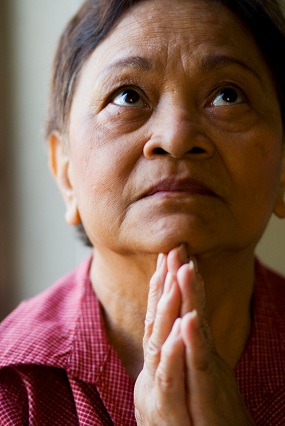 बूढ़ी स्त्री प्रार्थना करते हुए