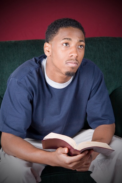 young contemplative man holding Bible