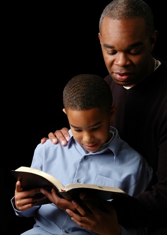 formation du caracatère du jeune enfant chrétien; père et fils lisant ensemble la Bible
