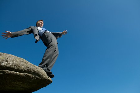 man about to fall off the edge of a cliff