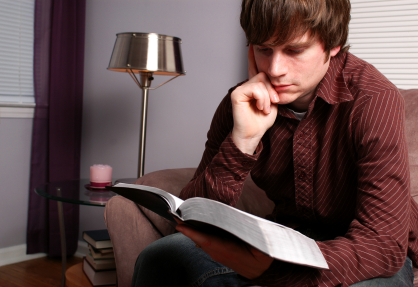 young contemplative man holding Bible