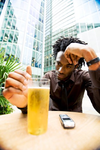 Man contemplating a drink of alcohol