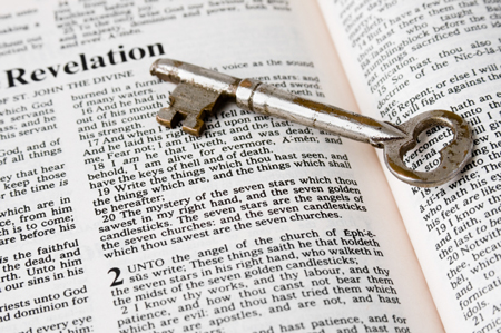 nyckel som ligger på en öppen Bibel (Uppenbarelseboken)