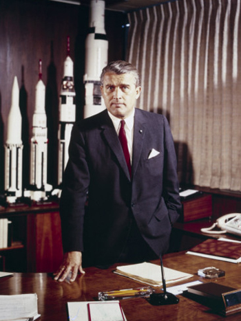 فون براون في مايو ١٩٦٤ مع نماذج من صواريخ زحل التي من شأنها دفع سباق الولايات المتحدة إلى القمر.