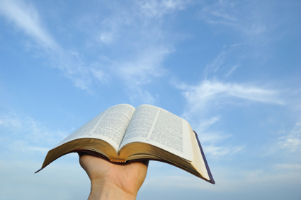 Open Bible being held up to the sky