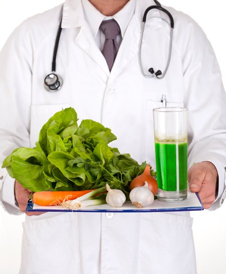 docteur en blouse blanche, un stéthoscope autour du cou, un plateau de jus vert frais de légumes à la main, salade verte, carotte, oignon, ail, poireau