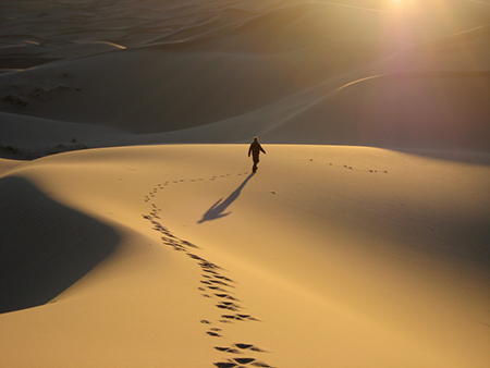 man walking alone in the desert