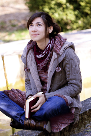 mujer joven que sostiene la Biblia y mirando al cielo