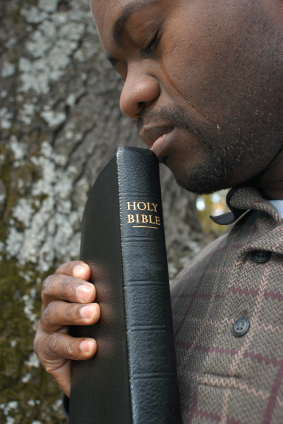 man holding Bible with tears running down his face
