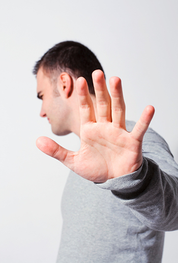 Man, refusing to listen, holding his hand up