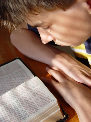 young boy reading Bible