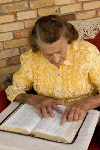 बूढ़ी औरत बाइबिल पढ़ते हुए