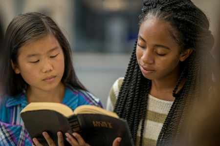 two girls reading the Bible