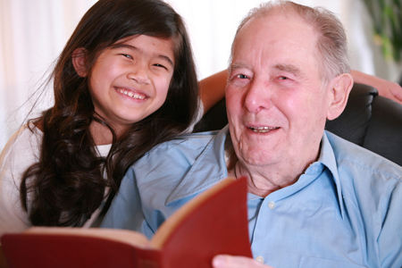 grandfather reading Bible to granddaughter