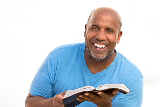 smiling man holding Bible