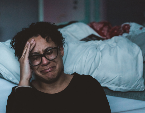 repentant; femme pleurant des larmes de repentance, au pied du lit, dans une chambre.