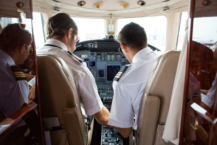 pilote et copilote dans un cockpit d’avion ayant discutant de façon technique