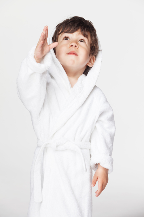 Un enfant obéissant regardant vers le Ciel, en robe de chambre blanche