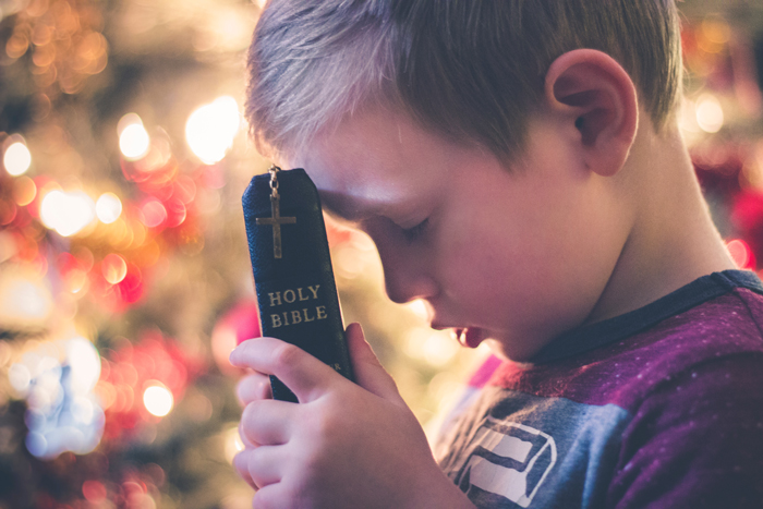 garçon en prière avec sa Bible