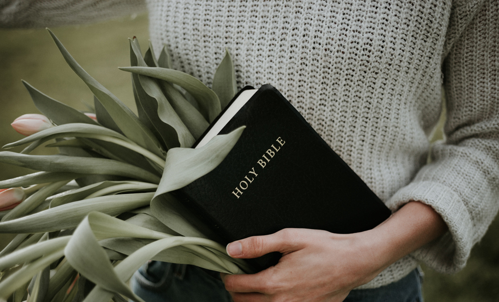 girl holding bible and tulips 